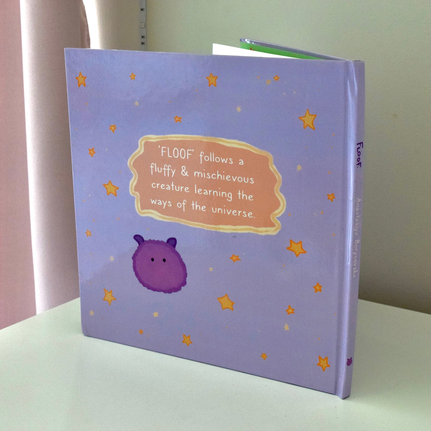 Back cover of 'Floof' storybook. Tiny purple fluffy alien pictured. 